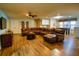 Spacious living room with a large brown leather sectional couch, ceiling fan, and wood flooring at 2147 Tripoli Ct, Kissimmee, FL 34747