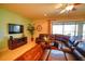Cozy living room with a plush leather sectional, large TV, and sliding glass doors to the outdoor patio at 2147 Tripoli Ct, Kissimmee, FL 34747