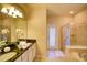 Bright main bathroom features double sinks, granite countertops, a soaking tub, and a glass shower at 2147 Tripoli Ct, Kissimmee, FL 34747