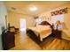 Main bedroom with decorative lamps, a large bed, wood-style flooring, and neutral walls at 2147 Tripoli Ct, Kissimmee, FL 34747