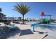 Resort-style pool area with colorful splash pad, palm trees, and plenty of lounge chairs and umbrellas at 2147 Tripoli Ct, Kissimmee, FL 34747