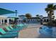 Beautiful pool area with rows of lounge chairs and umbrellas overlooking the luxurious community clubhouse at 2147 Tripoli Ct, Kissimmee, FL 34747