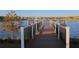 Scenic waterfront view from the community pier, offering a tranquil setting with lush landscaping and a distant fountain at 2147 Tripoli Ct, Kissimmee, FL 34747