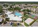 Aerial view showcasing the community pool, clubhouse, and sports courts, all nestled amidst lush greenery and residential buildings at 2322 Silver Palm Dr, Kissimmee, FL 34747