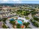Aerial view of the community featuring pool, sports courts, clubhouse, and surrounding residential buildings in a scenic landscape at 2322 Silver Palm Dr, Kissimmee, FL 34747