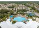Aerial view of the community showcasing pool, clubhouse, sports courts, and surrounding residential buildings in a sunny landscape at 2322 Silver Palm Dr, Kissimmee, FL 34747