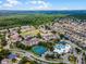 Expansive aerial view of a community with residential buildings, tennis courts, pool, clubhouse, and lush greenery in the surroundings at 2322 Silver Palm Dr, Kissimmee, FL 34747