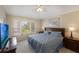 This bedroom includes large windows, ceiling fan and warm lighting, and a TV for relaxing entertainment at 2322 Silver Palm Dr, Kissimmee, FL 34747