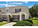 Charming two-story townhome with beige exterior, red shutters, and well-maintained landscaping at 2322 Silver Palm Dr, Kissimmee, FL 34747