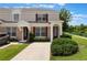 Charming two-story townhome with beige exterior, red shutters, and well-maintained landscaping at 2322 Silver Palm Dr, Kissimmee, FL 34747