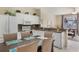 Open kitchen and dining area with white cabinets, granite counters, and views into the living area at 2322 Silver Palm Dr, Kissimmee, FL 34747