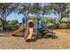 Community playground featuring slides, climbing structures and stairs with a wood chip base under a canopy of leafy trees at 2322 Silver Palm Dr, Kissimmee, FL 34747