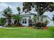 Lush landscaping surrounds this white single-story home, creating a tropical curb appeal at 2341 Stone Cross Cir, Orlando, FL 32828