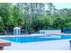 Community pool with clear blue water surrounded by lounge chairs and lush landscaping at 2341 Stone Cross Cir, Orlando, FL 32828
