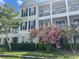 A charming multi-story condo featuring dual balconies, black shutters, lush landscaping, and beautiful flowering crepe myrtles at 239 Longview Ave # 107, Celebration, FL 34747