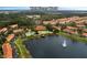 Aerial view of the resort community near Walt Disney World, with a lake, pools, and tile-roofed buildings at 3015 Yellow Lantana Ln, Kissimmee, FL 34747