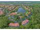 Aerial view of the resort community, with a lake, pools, playgrounds, and tile-roofed buildings at 3015 Yellow Lantana Ln, Kissimmee, FL 34747