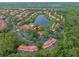 Aerial view of the resort community, with a lake, pools, playgrounds, and tile-roofed buildings at 3015 Yellow Lantana Ln, Kissimmee, FL 34747