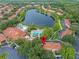 Aerial view of the community featuring a lake, pool, clubhouse, and lush green landscaping at 3015 Yellow Lantana Ln, Kissimmee, FL 34747