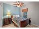 Cozy bedroom with a ceiling fan, wood-look flooring, and a window with striped blinds at 3015 Yellow Lantana Ln, Kissimmee, FL 34747
