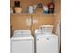 Convenient laundry area with washer, dryer, and overhead shelving for efficient storage solutions at 3015 Yellow Lantana Ln, Kissimmee, FL 34747