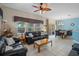Bright living room leading to a dining area, featuring tile floors, natural light, and sliding glass doors at 3015 Yellow Lantana Ln, Kissimmee, FL 34747