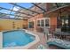 Backyard pool area enclosed with screen, including patio furniture for comfortable outdoor living and dining at 3015 Yellow Lantana Ln, Kissimmee, FL 34747