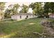 Back of house, with lush green backyard surrounded by fences and trees at 3661 Se 131St Pl, Belleview, FL 34420