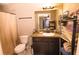 Cozy bathroom featuring a vanity with dark cabinets and a mirror reflecting the bedroom at 3661 Se 131St Pl, Belleview, FL 34420