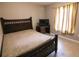 Cozy bedroom with a dark wooden bed frame, desk, and neutral-toned walls, illuminated by natural light at 3661 Se 131St Pl, Belleview, FL 34420
