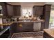 Stylish kitchen with dark cabinets, stainless steel appliances, and charming decor accents by the window at 3661 Se 131St Pl, Belleview, FL 34420