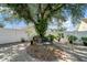 Landscaped backyard featuring a beautiful mature tree, stone detail, and a white fence for added privacy at 3738 Crossing Creek Blvd, St Cloud, FL 34772