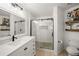 Bright bathroom featuring a glass-enclosed shower with stylish tile work, a modern vanity, and neutral decor at 3738 Crossing Creek Blvd, St Cloud, FL 34772
