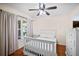 Cozy bedroom with a white bed frame, hardwood floors, and a bright window that lets in natural light at 3738 Crossing Creek Blvd, St Cloud, FL 34772