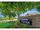 Charming community entrance sign for Cross Creek, adorned with lush landscaping and a welcoming brick facade at 3738 Crossing Creek Blvd, St Cloud, FL 34772