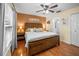Charming bedroom featuring wood floors, a rustic wood headboard, and access to an ensuite bathroom at 3738 Crossing Creek Blvd, St Cloud, FL 34772