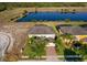 Aerial view of home with a two-car garage, lawn, and a scenic pond view at 389 Yellow Snapdragon Dr, Davenport, FL 33837