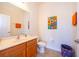 Bright bathroom with vibrant artwork, a wooden vanity, and tiled flooring at 389 Yellow Snapdragon Dr, Davenport, FL 33837
