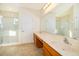 Well-lit bathroom features double sinks, a spacious shower, and wood-finished cabinets at 389 Yellow Snapdragon Dr, Davenport, FL 33837