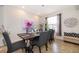 Well-lit dining room with a modern chandelier, accent wall art, and stylish furnishings at 389 Yellow Snapdragon Dr, Davenport, FL 33837