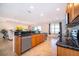 Modern kitchen with granite countertops, stainless steel appliances, and tile flooring leading to the living room at 389 Yellow Snapdragon Dr, Davenport, FL 33837
