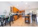 Spacious kitchen with wooden cabinetry, stainless steel appliances, breakfast bar, and tile flooring at 389 Yellow Snapdragon Dr, Davenport, FL 33837