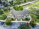 Drone view of the yellow and green townhome, showcasing the landscaping, parking and proximity to other homes at 4551 Jonafree Ln # 103, Kissimmee, FL 34746