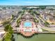 Aerial view of the community with pool, lake, clubhouse, and stylish townhomes surrounded by lush landscaping at 4551 Jonafree Ln # 103, Kissimmee, FL 34746
