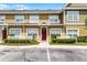 The exterior of this townhome has a red front door, white picket fence and tidy landscaping at 4551 Jonafree Ln # 103, Kissimmee, FL 34746