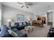 A cozy living room with a sofa, ceiling fan, and views of the dining area and kitchen at 4551 Jonafree Ln # 103, Kissimmee, FL 34746