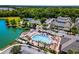 Aerial view of a community pool area with lounge chairs, palm trees, lake and apartment buildings in the background at 4551 Jonafree Ln # 103, Kissimmee, FL 34746