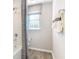 Bathroom with a bathtub shower featuring a gray curtain and a window at 5228 Bee Balm St, Lake Hamilton, FL 33851