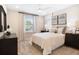 This bedroom offers a plush bed, a ceiling fan, and bright, natural light from the large window at 5228 Bee Balm St, Lake Hamilton, FL 33851