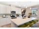 Well-lit kitchen with an island, stainless appliances, ample cabinet space, and open flow to the adjacent dining area at 5228 Bee Balm St, Lake Hamilton, FL 33851